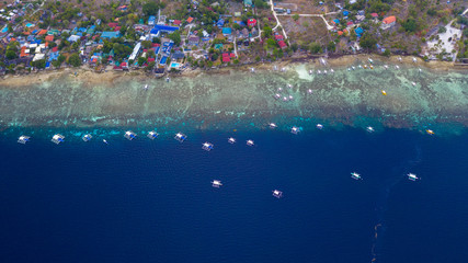 Wall Mural - Aerial top down view of boat moving in open sea with clear and turquoise water on over coral reef,  Boat left the tropical lagoon, Moalboal, Oslob, Cebu Island, Philippines.