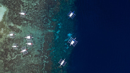 Wall Mural - Aerial top down view of boat moving in open sea with clear and turquoise water on over coral reef,  Boat left the tropical lagoon, Moalboal, Oslob, Cebu Island, Philippines.