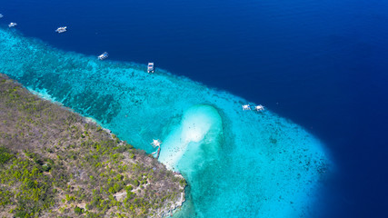 Wall Mural - Aerial view of the Sumilon island, sandy beach with tourists swimming in beautiful clear sea water of the Sumilon island beach, Oslob, Cebu, Philippines.