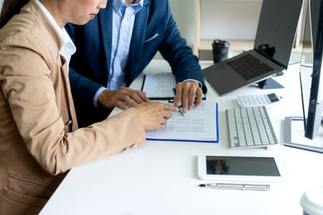 Wall Mural - business man and woman sit at the table looking at computer