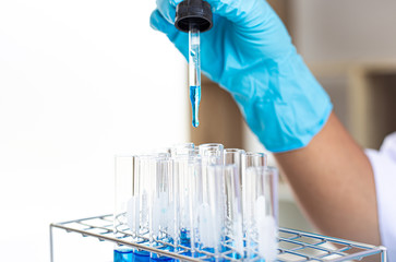 Scientists are carrying blue chemical test tubes to prepare for the determination of chemical composition and biological mass in a scientific laboratory, Scientists and research in the lab Concept.