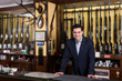 © JackF - Positive man  standing near showcase with rifles store