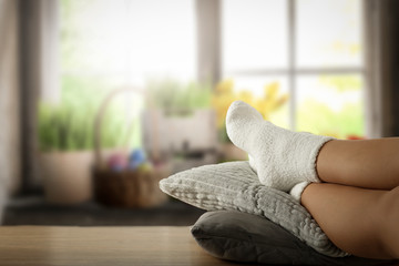 Legs in socks on the background of the spring window with free space for an advertising product