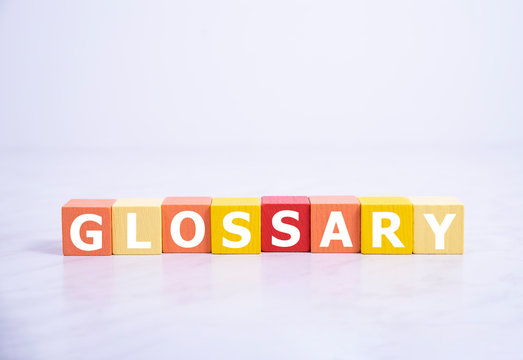 Glossary - word from wooden blocks with letters, alphabetical list with words meanings dictionary glossary concept, top view on white background