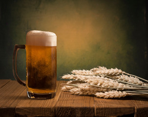 Wall Mural - Glass beer with hop cones and wheat ears on dark wooden background. Beer brewery concept. Beer background. top view with copy space