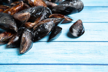 Fresh raw mussels on blue wooden backgound