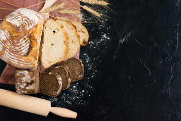 freshly baked homemade rustic bread on a dark background. With copy space. View from above.