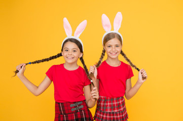 Wall Mural - with friend. happy easter. spring is coming. happy childhood concept. small girls bunny ears yellow background. funny little sister kids celebrate easter. egg hunt begin. traditional spring holiday