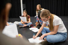Focused Junior High Girl Student Reviewing Script In Drama Class