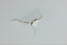 Puncture Crack Hold In Ceiling Wall Of White Painrtd Drywall