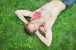 © YouraPechkin - From above of handsome gentleman with naked torso resting on green grass. Sexy guy with three-leaf clover in mouth keeping hands behind head and looking up. Concept of relax and nature.