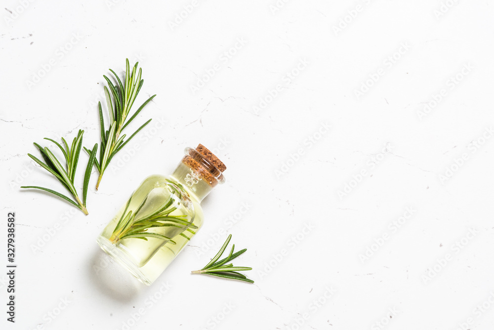 Rosemary essential oil in the bottle on white. - obrazy, fototapety, plakaty 
