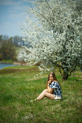 Wall Mural - beautiful girl in a dress walking in the spring forest where the trees bloom