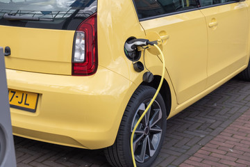 Wall Mural - yellow Electric car on charching station plugged