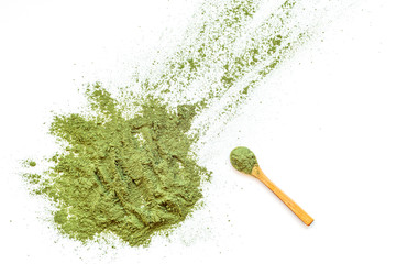 Powdered green matcha tea and wooden spoon isolated on white background