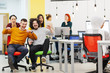 © Nikola Spasenoski - Colleagues having fun on work at the office. Girls pushing boys on chairs with wheels.