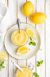 Homemade tangy lemon curd decorated with fresh fruit in a glass jars on rustic wooden background
