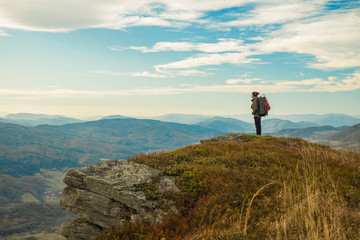 hiking mountain top edge of cliff highland scenic view with backpacker male person stay and looking side ways life style poster concept empty copy space for text