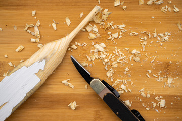 wood carving or wood crafting background over a pine tree wood table with a cutting knife 