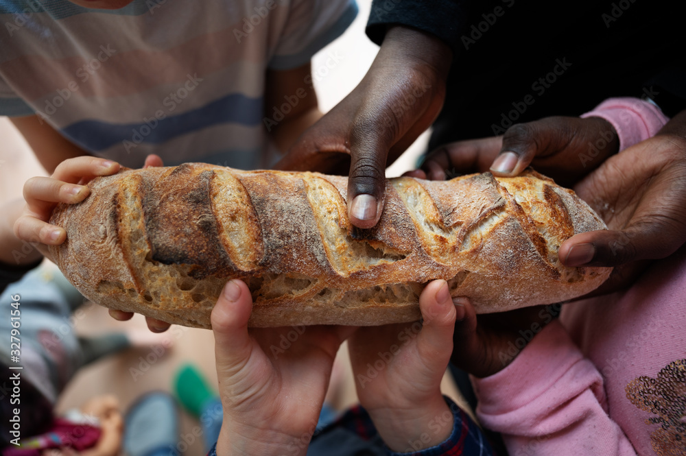 Black and white children holding loaf of bread - obrazy, fototapety, plakaty 