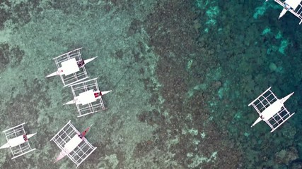 Wall Mural - Aerial top down view of boat moving in open sea with clear and turquoise water on over coral reef,  Boat left the tropical lagoon, Moalboal, Oslob, Cebu Island, Philippines, 4K.