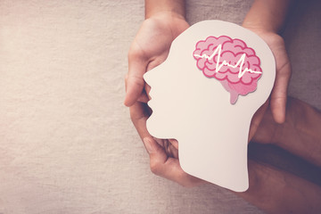 adult and child hands holding encephalography brain paper cutout, epilepsy and alzheimer awareness, 