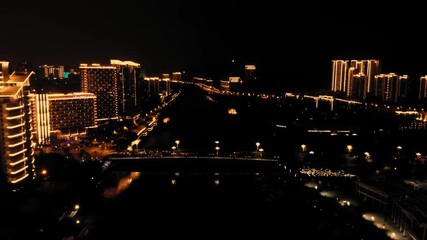 Poster - flying above illuminated town slowly traffic in urban city at night time