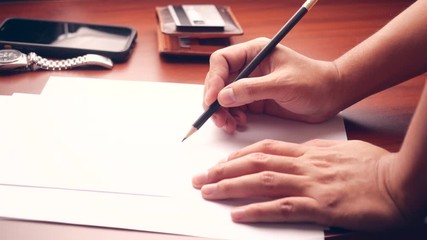 Poster - Male manager putting his ideas and writing business plan at workplace. man holding pencil making notes in paper documents on the table in office