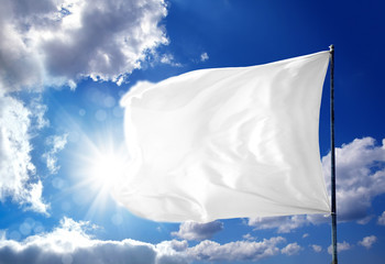 Wall Mural - Conceptual image of waving blank white flag over sunny blue sky