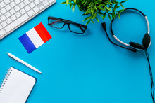 Learn French Online. Concept With Flag, Headset And Keyboard On Blue Background Top-down Copy Space