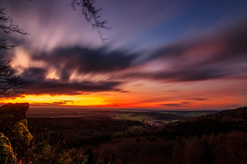 Wall Mural - nice long exposure from the spikes in the taunus Germany.  The picture shows a wonderful and colorful sunset.  with a rock in the foreground...sunset in the mountain