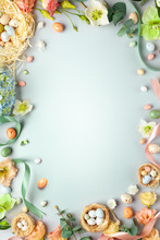 Happy Easter Concept With Easter Eggs In Nest And Spring Flowers. Easter Background With Copy Space. Flat Lay.