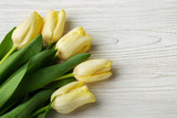 Fototapeta Tulipany - Tulip - bouquet yellow tulips on white wood background