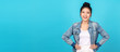 Banner of Happy asian woman standing and feeling happiness and confident on blue background. Cute asia girl smiling or laughing wearing casual travel uniform in jeans shirt and keeping hands on hips