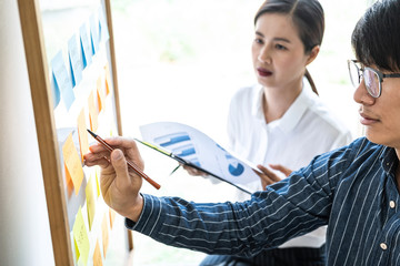 Poster - Two creative Business people meeting and planning use post it notes sticky note on board to share idea, Analysis data charts and graph with teamwork strategy brainstorming