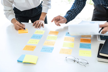 Poster - Two creative business people meeting and planning use post it notes sticky note on desk to share idea, Analysis data chart and graph with teamwork strategy brainstorming in office