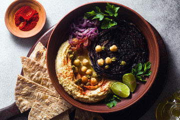 Wall Mural - a bowl of hummus, baked purple cabbage and pickled red onion with a tortilla and smoked paprika