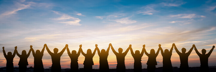 silhouette of group happy business team making high hands over head in beautiful sunset sky evening 