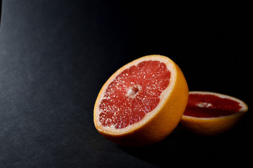 bright red sliced ​​grapefruit close-up on a gray background horizontal orientation