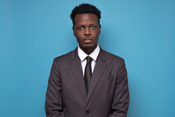 Canvas Print - Handsome young African American serious businessman wearing a black suit and tie