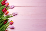 Fototapeta Tulipany - Spring flowers composition on the wooden background.Top view colorful tulips  on a wooden surface. Copy space.