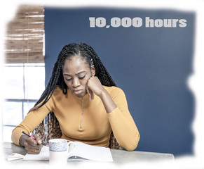 Wall Mural - 10000 hours typographic quote. Young, African American woman working from home on her laptop in the kitchen.