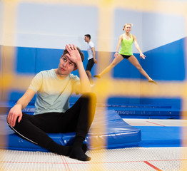 Weary teenager sitting on trampoline