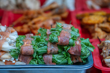 Wall Mural - Marinated meat with herbs on the counter of a street restaurant for grilling in mountain village Sapa, north Vietnam, close up