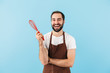 Cheerful young bearded man wearing apron standing