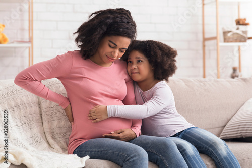 Fotografía Caring little daughter comforting pregnant mom that suffering from prenatal cont
