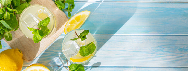 lemonade and ingredients on blue wood background, copy space