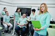 © AS Photo Family - Medical theme .Portrait of female doctor with clipboard against group of doctors meeting in the mri office at diagnostic center in hospital.