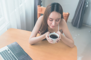 Lazy woman drinking morning coffee at home.