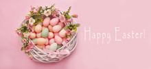 Colorful Easter Eggs In Nest On Pastel Color Background With Flowers, Copy Space. Easter Decorations. Easter Background With Painted Eggs In Nest, Vintage Style, Top View. Spring Greeting Card